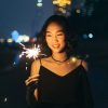 A woman having fun with a fireworks stick at night